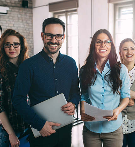 Group of people within a business who are smiling at work.